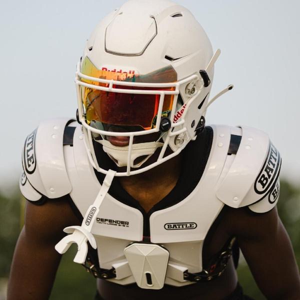 A football player wearing a helmet and shoulder pads A football player wearing a helmet and shoulder pads