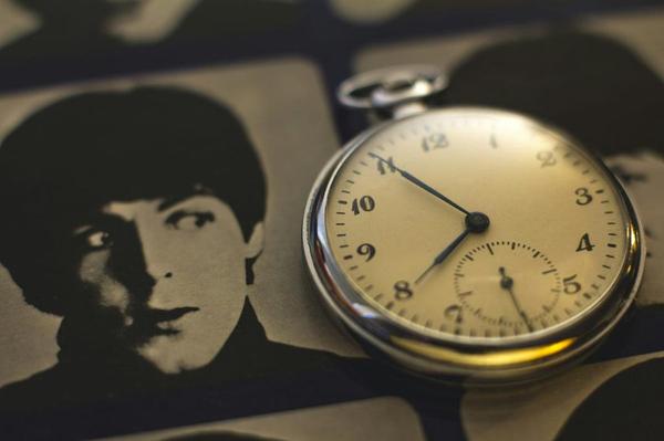 A black and white photograph of Paul McCartney looking at a stopwatch A black and white photograph of Paul McCartney looking at a stopwatch