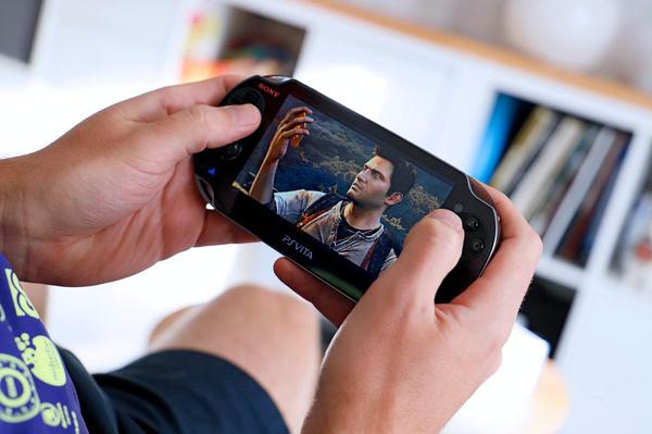 A person playing Uncharted: Golden Abyss on a PlayStation Vita.
