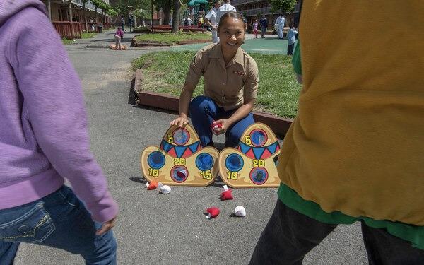 Lance Cpl. Julie Kataviravong plays a ball-toss game with children during a community relations project at the HOPE House shelter for homeless families in the Bronx during Fleet Week 2014. Women on active duty often pay more out of pocket for their uniforms than men do.