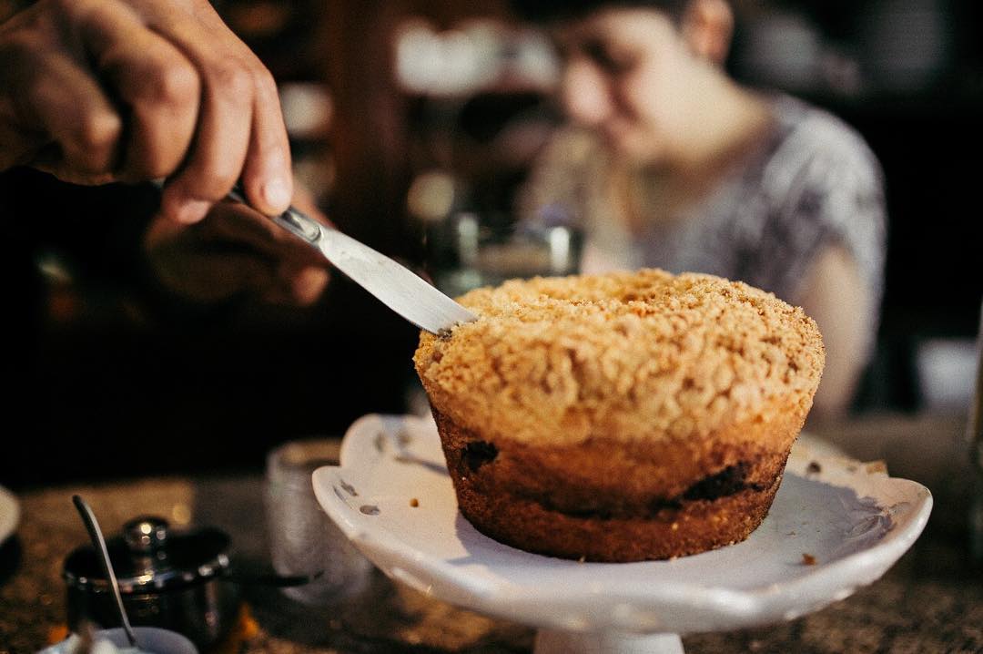 Deliciosa cuca servida na padaria artesanal Ateliê Sustenta Capão, feita pelas mãos fortes e talentosas de José Carlos de Anunciação, também no Morro do Piolho, extremo Sul de São Paulo. (Crédito: Thaís Lopes/THZ Filmes).