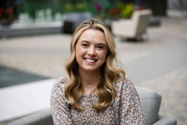 Blonde woman wearing a flower top and smiling at the camera Blonde woman wearing a flower top and smiling at the camera
